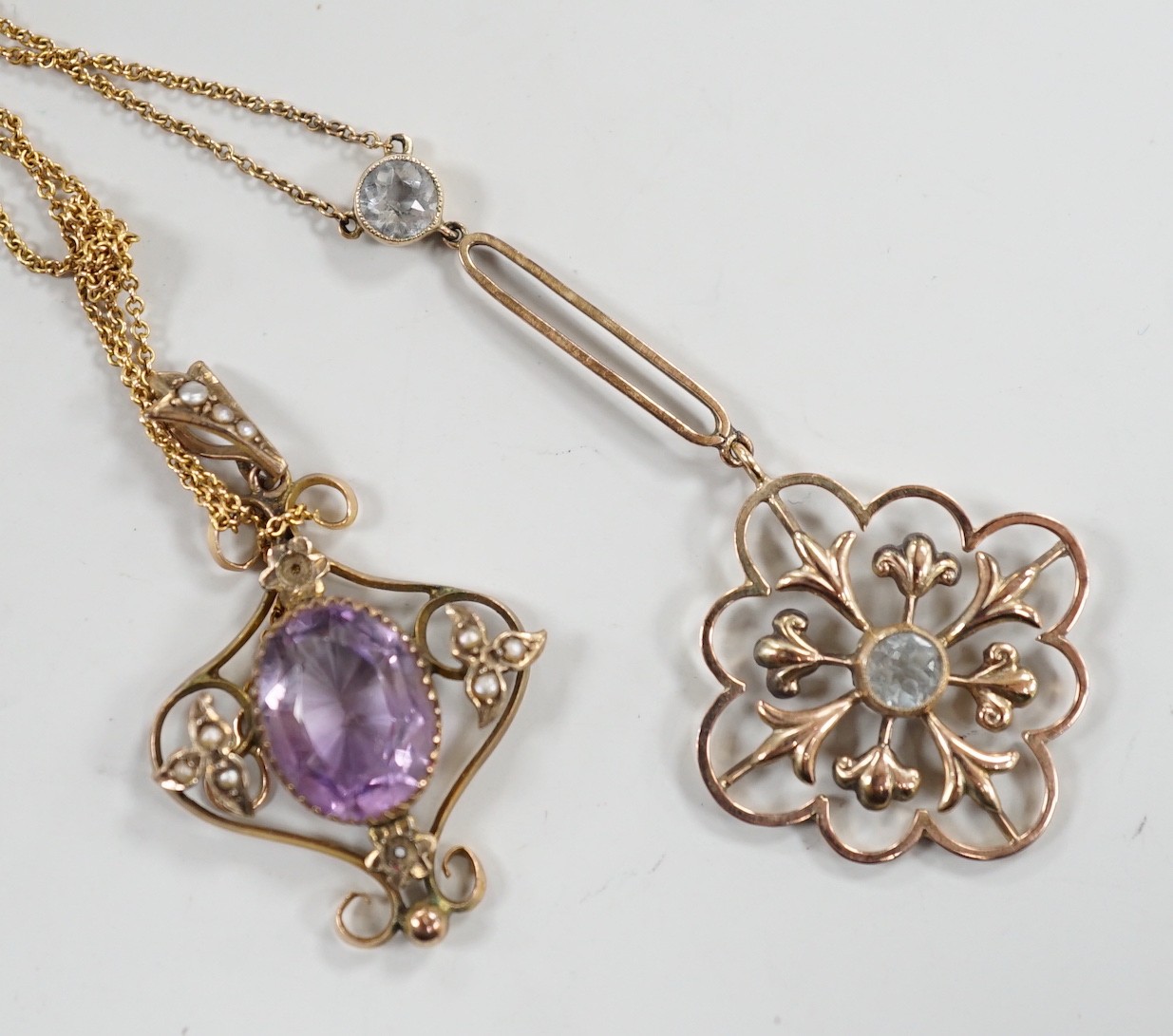 Two Edwardian 9ct and gem set pendants, including amethyst and seed pearl and two stone aquamarine drop, 53mm on a yellow metal chain, gross weight 6.3 grams.